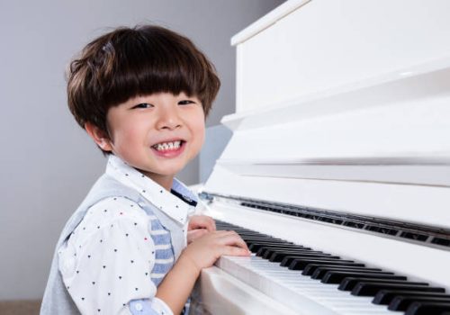 Happy Asian Chinese little boy playing piano in the living room at home. Happy Asian Chinese little boy playing piano in the living room at home.